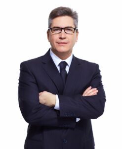 Man in a suit with glasses, embodying executive professional poise against a white background.
